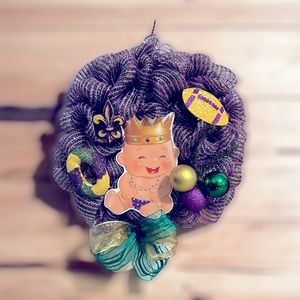 This is a adorable Mard Gras wreath has a big ole baby’s in the middle